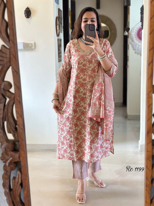 Woman taking a mirror selfie wearing a floral dress in a room with wooden decor.