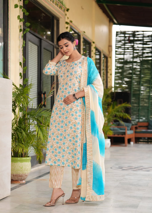 Woman in traditional outfit with blue and beige dupatta standing outdoors.