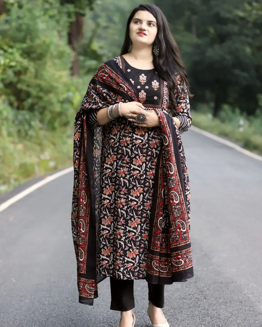 Woman wearing a traditional outfit with a floral pattern on a road with greenery in the background