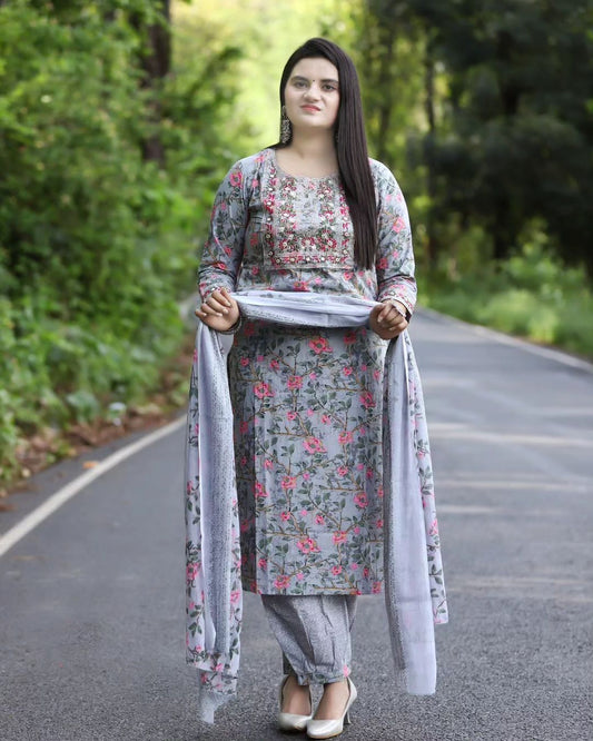 Woman in floral dress standing on a road with greenery in the background