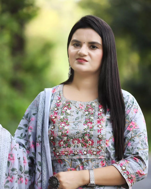 Woman wearing a floral embroidered outfit with a blurred green background