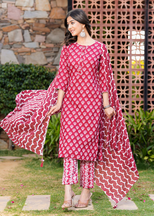 Woman wearing a pink and white patterned traditional outfit in an outdoor setting.