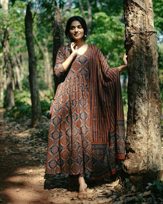 Woman in a patterned dress standing in a forest