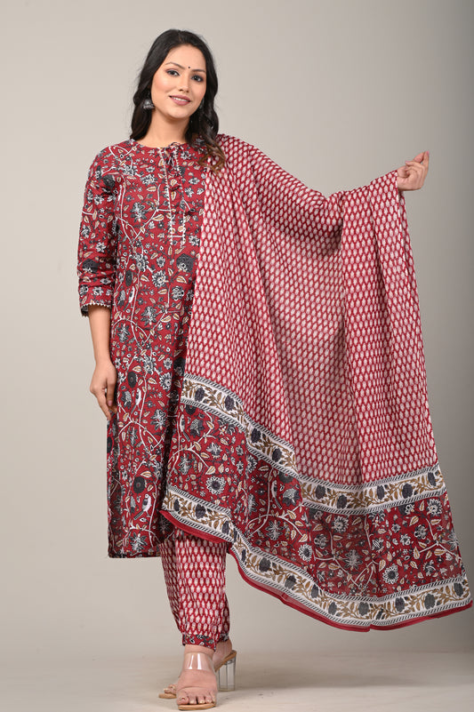 Woman holding a red and white patterned dupatta with a matching outfit on a plain background