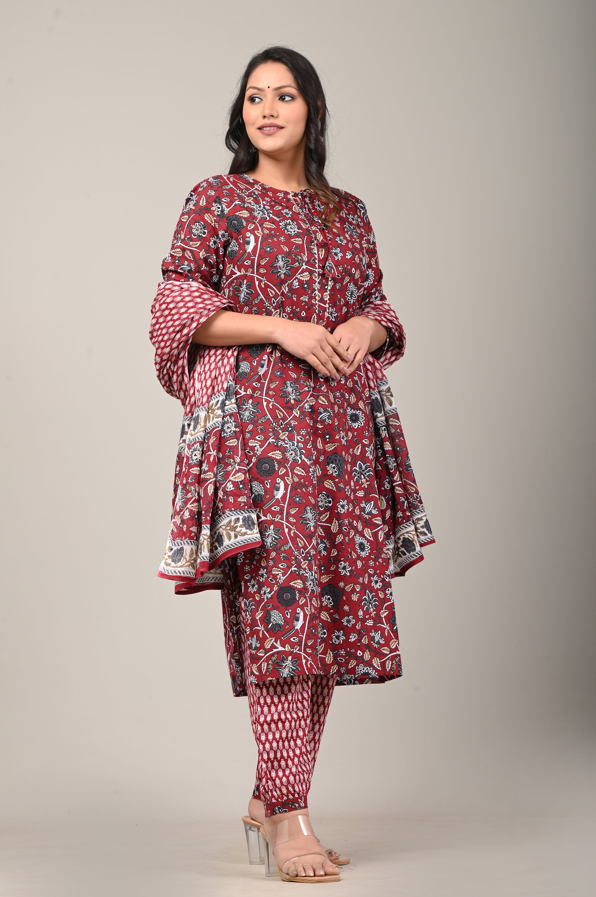 Woman wearing a red patterned outfit on a plain background